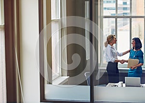 Theres lots of room to grow in this company. two businesswomen shaking hands in an office.