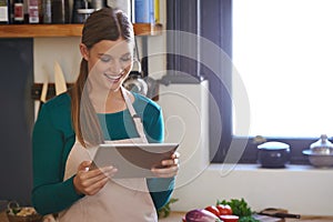 Theres so many great recipes on this website. a young woman looking for online recipes on her digital tablet.