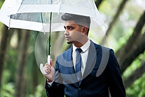 Theres new opportunity around every corner. a young businessman holding an umbrella on a rainy day in the city.