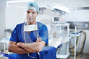 Theres no challenge I cant handle. A handsome doctor standing in scrubs in the operating theatre.