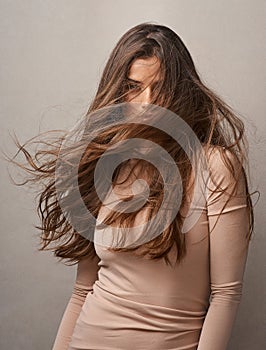 Theres no such thing as a bad hair day. Portrait of a beautiful young woman posing with the wind in her hair in studio.