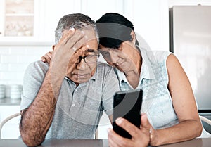 Theres nothing we cant face together. a senior couple looking unhappy while using a phone at home.