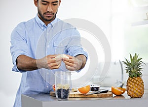 Theres only one way to start the day. Shot of a man making himself a smoothie at home.