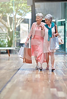 Theres a sale that caught my attention. Full length shot of a two senior women out on a shopping spree.
