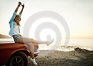 Theres something about summer that lets us free. a young woman enjoying a road trip along the coast.