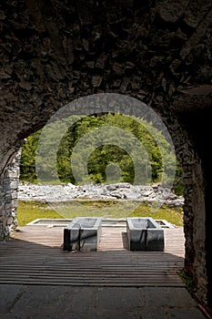 Thermal bath tubs with a view of the river and Swiss nature. View from inside a cave