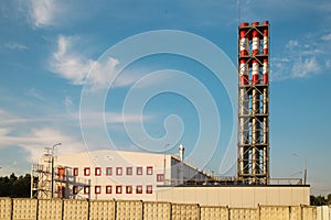 Thermal gas substation with a block of paired metal pipes against a background of blue sky and white clouds on a sunny day