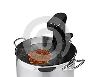 Thermal immersion circulator and meat in pot on white background. Vacuum packing for sous vide cooking