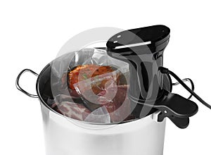 Thermal immersion circulator and meat in pot on white background. Vacuum packing for sous vide cooking