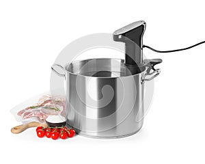 Thermal immersion circulator in pot and ingredients on white background. Sous vide cooking