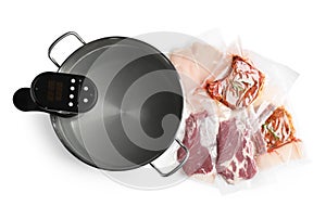 Thermal immersion circulator in pot and meat on white background, top view. Vacuum packing for sous vide cooking