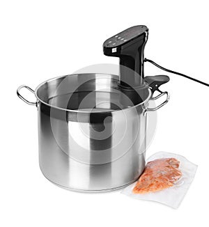 Thermal immersion circulator in pot and meat on white background. Vacuum packing for sous vide cooking