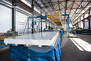 Thermal insulation sandwich panel production line for construction. Manufacturing storage with machine tools, roller conveyor