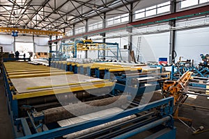 Thermal insulation sandwich panel production line for construction. Manufacturing storage with machine tools, roller conveyor