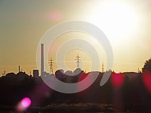 Thermal power plant and electricity lines silhouette at sunset