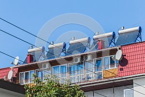 Thermal solar panels and water heater alternative technologies of water heating on the roof of the hotel against the blue sky