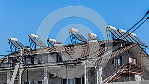 Thermal solar panels and water heater alternative technologies of water heating on the roof of the hotel against the blue sky