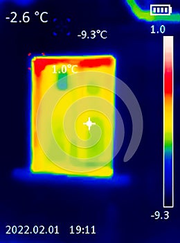 A thermographic image of a building window showing different temperatures in different colors, from blue indicating cold to red