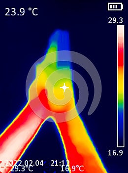 A A thermographic image of a hand with a human heart, showing different temperatures in different colors, from blue indicating