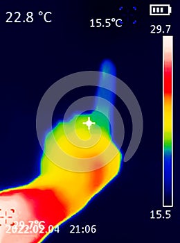 A A thermographic image of a hand with a human heart, showing different temperatures in different colors, from blue indicating