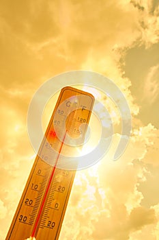 Thermometer against background hot, summer yellow sun.Hot weather and high air temperature.