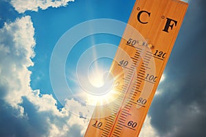 Thermometer, blue sky with clouds, bright sun.  The heat. Hot summer day