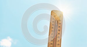 Thermometer with blue sky and sun, measure the temperature, weather forecast, global warming and environment discussion, heat wave