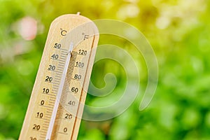 Thermometer with blur green background for cooling air low temperature from plant tree garden