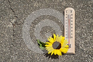 Thermometer on concrete background showing high temperature. Summer heat concept