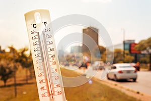 Thermometer in front of cars and traffic during heatwave photo