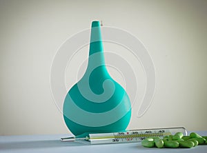 Thermometer in a glass of water and medication for the table