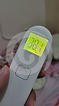 thermometer with high fever 38 celcius yellow lamp and background photo