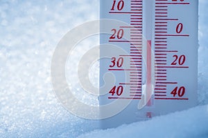 The thermometer lies on the snow in winter showing a negative temperature. Meteorological conditions in a harsh climate in winter