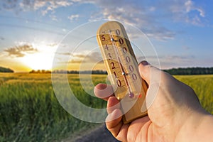 Thermometer for measuring temperature in nature against the background of the sky in the summer hot weather