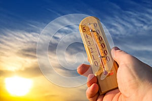 Thermometer for measuring temperature in nature against the background of the sky in the summer hot weather