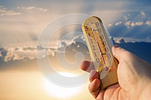 Thermometer for measuring temperature in nature against the background of the sky in the summer hot weather