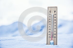 Thermometer on the mountains in the snow shows temperatures below zero. Low temperatures in degrees Celsius and fahrenheit