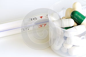 Thermometer and pills pharmaceuticals concept