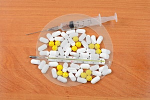 Thermometer with pills and a syringe