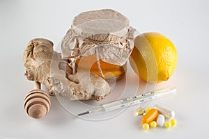 Thermometer, pills and vitamins VS jar of honey , ginger, lemon