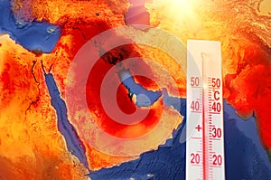 Thermometer with a record high temperature of fifty degrees Celsius, against the backdrop of the Arabian Peninsula, Persian Gulf.