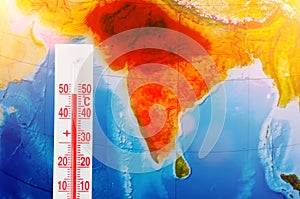 Thermometer with a record high temperature of fifty degrees Celsius, against the backdrop of the continent of the Indostan