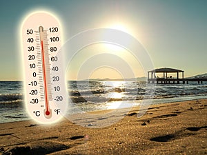 Thermometer showing the temperature rise in the summer sun and seaside photo koncept