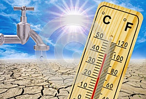 thermometer shows high temperature in summer heat with dryness and lack of water in field.