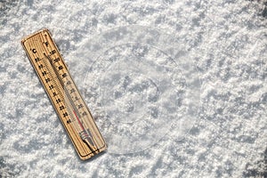 Thermometer in the snow with freezing temperatures photo