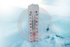 Thermometer on snow shows freezing temperature in celsius or farenheit photo