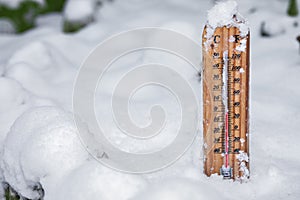 Thermometer on snow shows low temperatures under zero. Low temperatures in degrees Celsius and Fahrenheit. Christmas, freeze