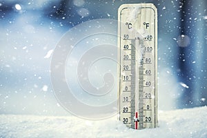 Thermometer on snow shows low temperatures under zero. Low temperatures in degrees Celsius and fahrenheit.