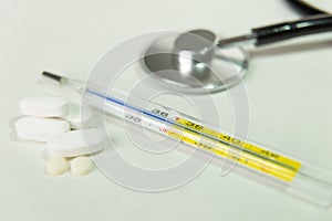 Thermometer and stetoscope on White background