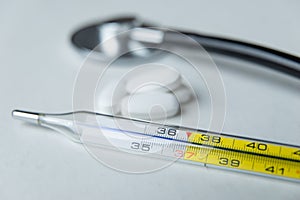 Thermometer and stetoscope on White background